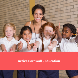 a teacher poses with smiling students doing pe, text reads "active cornwall - education"