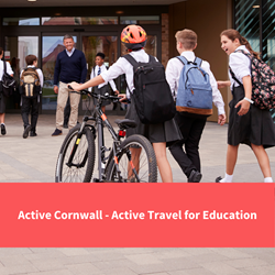 secondary students walking into school entrance, one is walking with a bike and helmet, text reads "active cornwall - active travel for education"