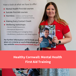 healthy cornwall staff member smiling at camera with mhfa booklet, text reads "mental health first aid"