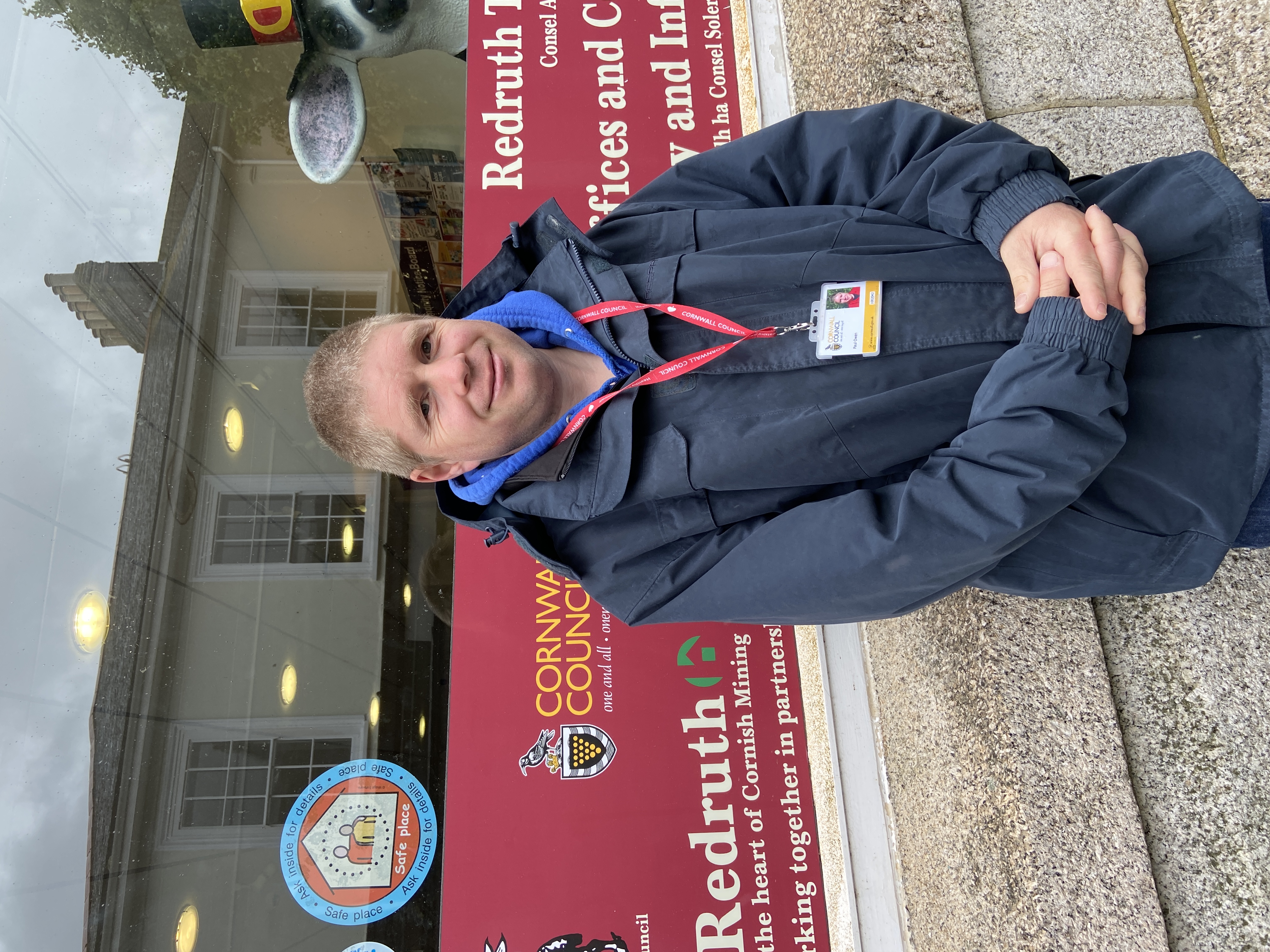 a member of the CHAMPs team stands outside Redruth Library showing the Safe places sticker in the windowRedruth Library - SP